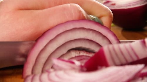 Knife Slicing a Red Onion into Thin Rings