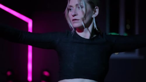 Live Camera Dancing Woman in a Hall with Neon Lighting Closeup of the Active Waving of Arms and