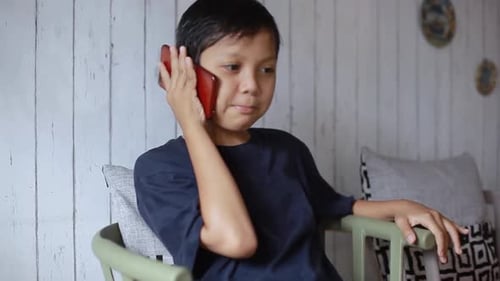 Happy Boy Talking on Cell Phone Indoors