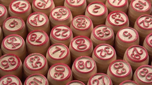 Lotto board game with wooden barrels with numbers close up rotate background side view. Bingo game