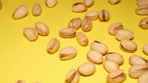 Pistachios Scattered on a Yellow Surface