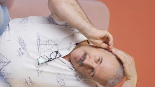 Man Combs His Mustache While Relaxing in Chair
