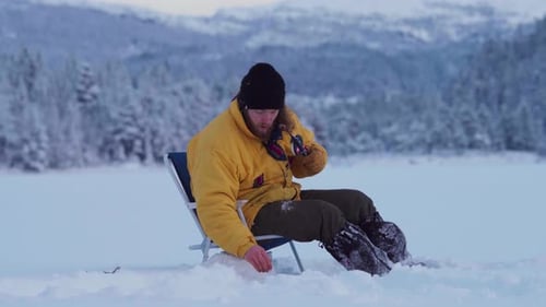 Man Ice Fishing On A Frozen Lake In Indre Fosen, Norway - wide