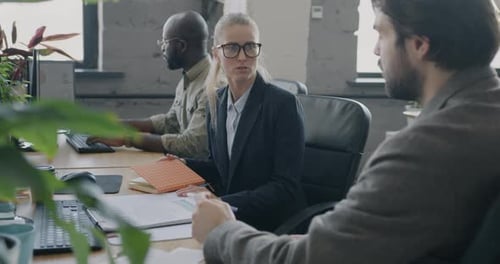 Office Workers Reviewing Paperwork at Desk