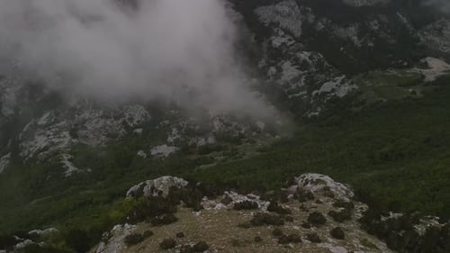bottom up backwards view from the canyon to the mountain over a isolated man with some clouds. think