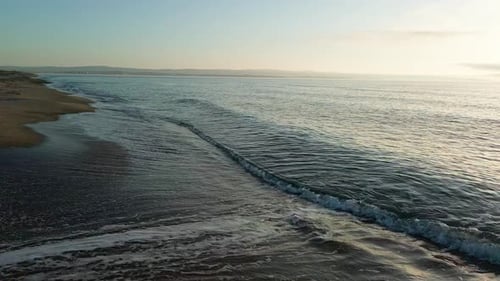 Black Sea and Beach Nearby Against a Sky with Clouds and a Dawn Sun
