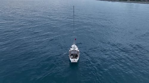 Aerial Drone View of Sailing Yacht Anchored in the Bay with Clear and Turquoise Water on the Sunset
