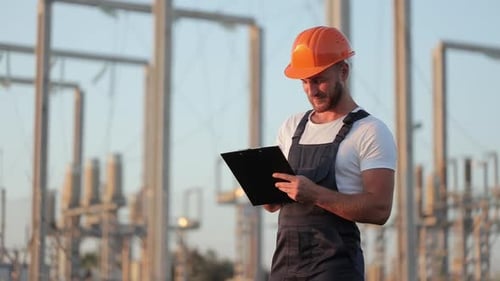 Technician with Checklist in Hands Standing at Power Station