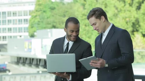 Men Collaborate With Technology in Urban Workplace