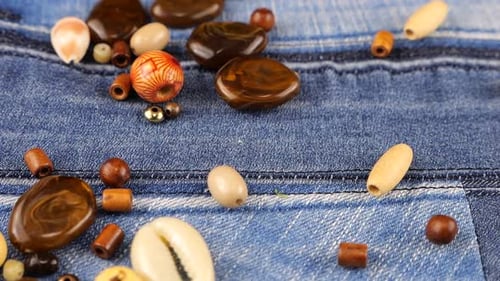 Wooden and Shell Beads Falling on Denim