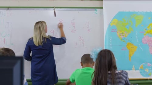 Un enseignant pose des questions de mathématiques aux élèves en classe