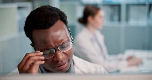 Overworked Doctor at Desk Rubs Face