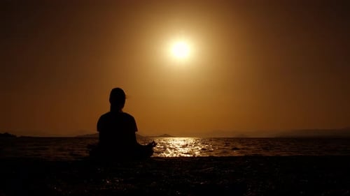 Meditating Figure Silhouette at Beach at Sunrise