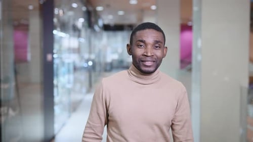 A Young African Man is Walking Through the Mall