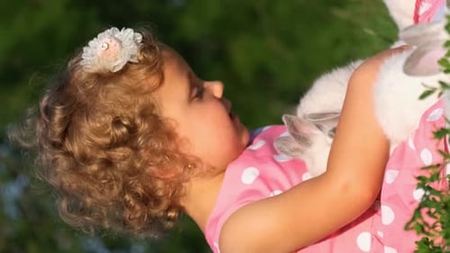 Girl Holds Rabbits Lovingly in Natural Light
