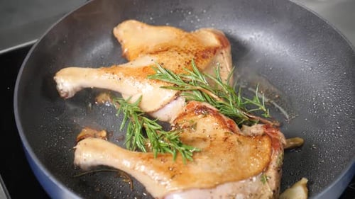 Duck Legs Sizzling in Skillet with Rosemary
