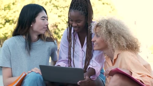 Three Happy Multiracial Friends Studying at a Park