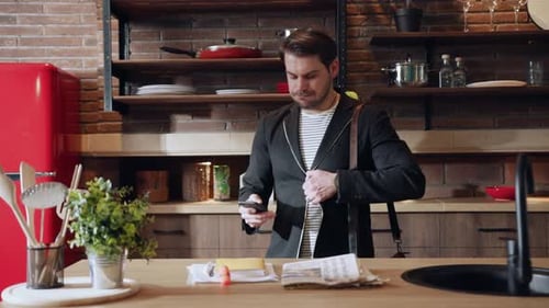 Man Uses Smartphone in Modern Urban Kitchen