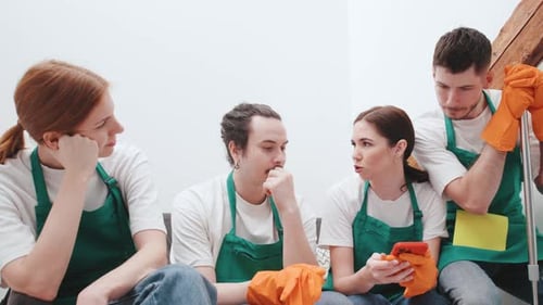 Smiling Cleaning Team Chatting and Using Mobile Device