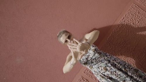 Stylish Woman Dancing in Front of Pink Wall