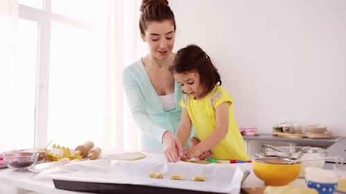 Woman and Girl Baking Cookies in Kitchen