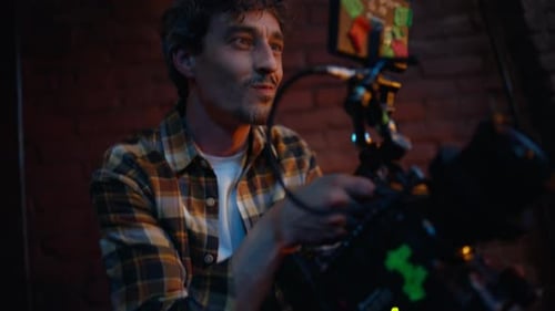 Professional Videographer Filming Club Performance in Dark Atmosphere Closeup