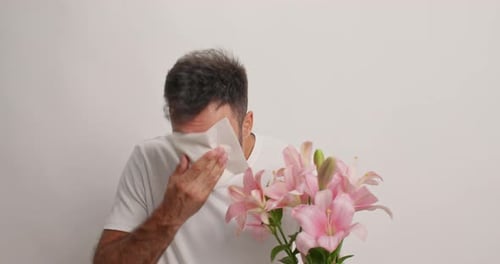 Adult Man with Allergies Holding Flowers