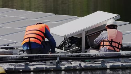 Schwimmendes Solarpanel auf dem Teich. Der Arbeiter wartet und überprüft schwimmende Photovoltaikmodule.