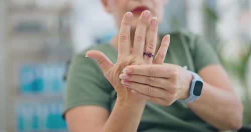 Older Adult Massaging Hand Joints Indoors