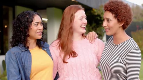 Three Friends Laughing Together Outside a House