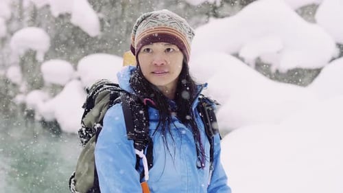 Woman Hiking in Snowstorm with Backpack