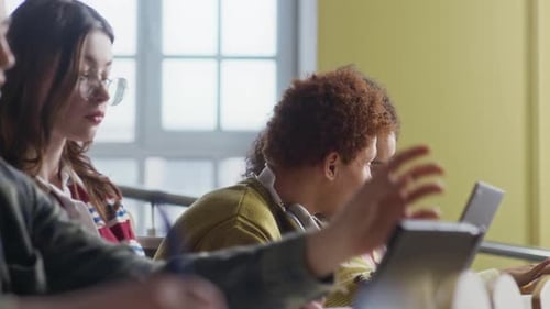 Divers camarades de collège utilisant des appareils numériques pendant les cours