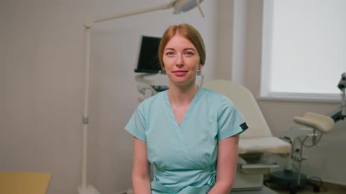smiling doctor gynecologist sits in gynecological office near ultrasound machine and gynecological