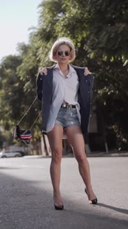 A beautiful professional model in a blue jacket poses for the camera. Autumn fashion. The trend.