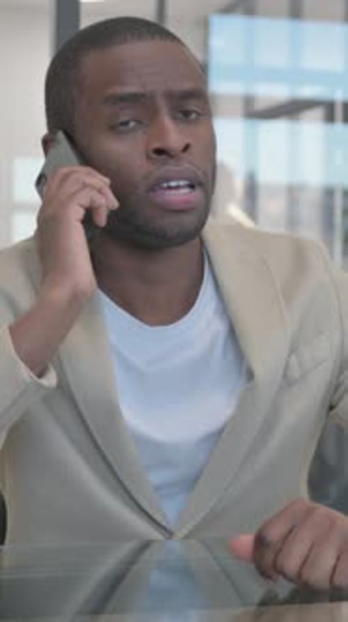 Man in Blazer Talking on Cell Phone Indoors