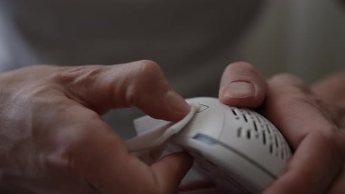 Hands Cleaning a White Computer Mouse