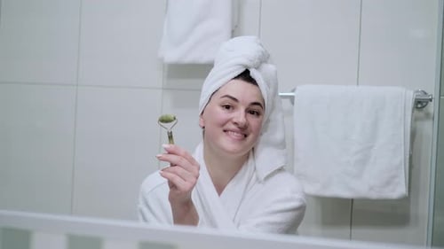Woman Holding a Facial Massage Roller in Bathroom