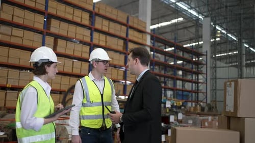 Blue collar workers are working and meeting at warehouse.