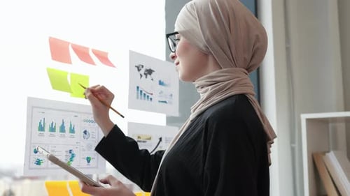 Businesswoman Analyzing Charts and Graphs in Office