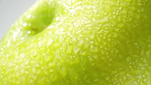 A green apple with droplets of water. macro video.