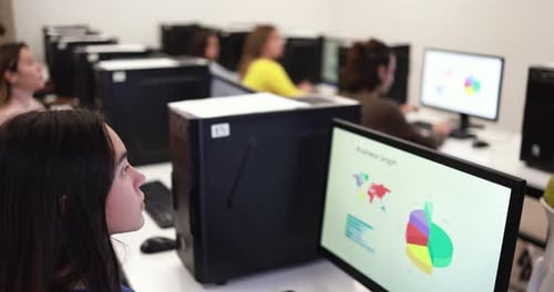 Young multiracial students learning digital technology in school computer classroom