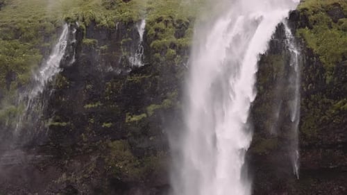 Powerful Waterfall Cascading Down Mossy Cliffside