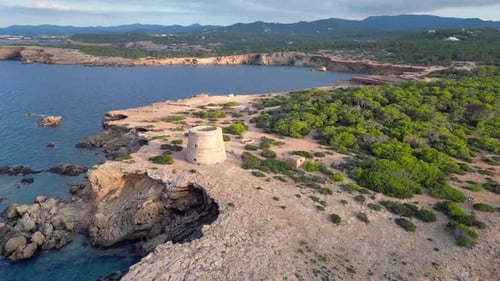 mediterranean coastal sunset ancient historic tower. Majestic aerial top view flight descending dron