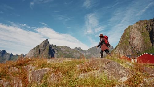 Woman Traveler Hipster with Red Backpack Walks Forward at Amazing Mountains and Valley View