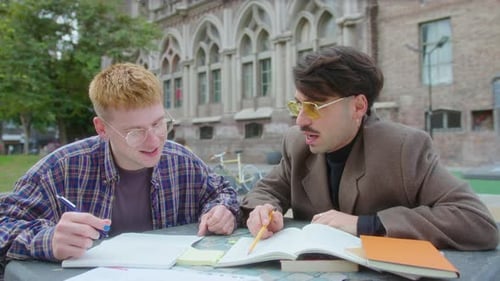Two College Students Doing Homework Outdoors on Campus