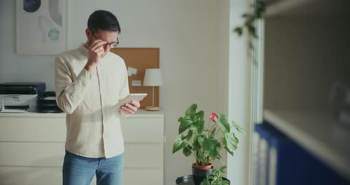 Contemplative Businessman Working On Digita Tablet In Office