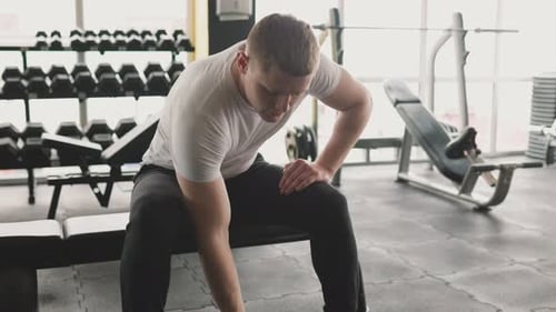 Man Lifting Dumbbell in Bright Gym