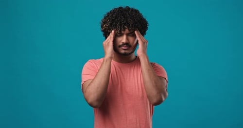 Young Man Massaging Temples in Frustration