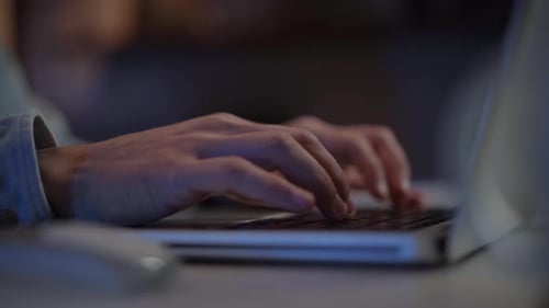 Nahaufnahme menschlicher Hände, die nachts auf der Laptoptastatur tippen Unbekannter weißer Mann, der online arbeitet