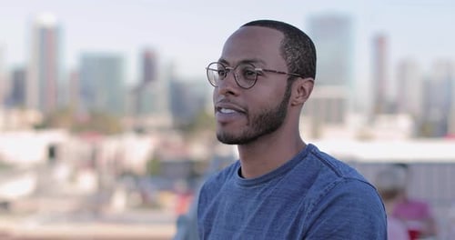 Young Man Smiling in Front of City Skyline